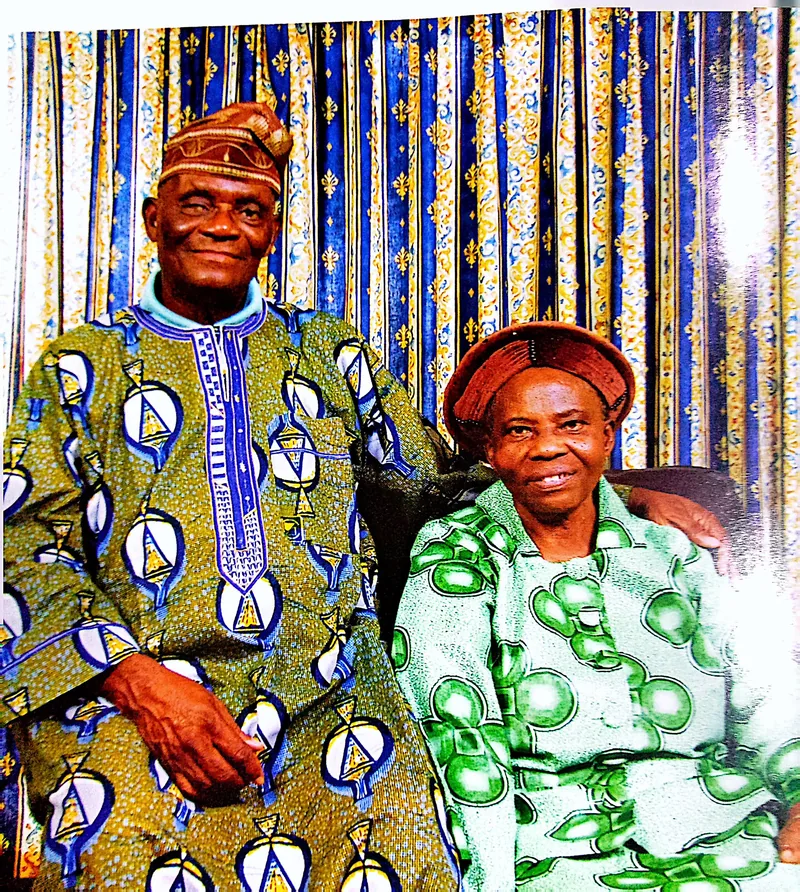 Papa Elkanah Osibanjo seated beside Mama Osibanjo, both in patterned traditional dress.
