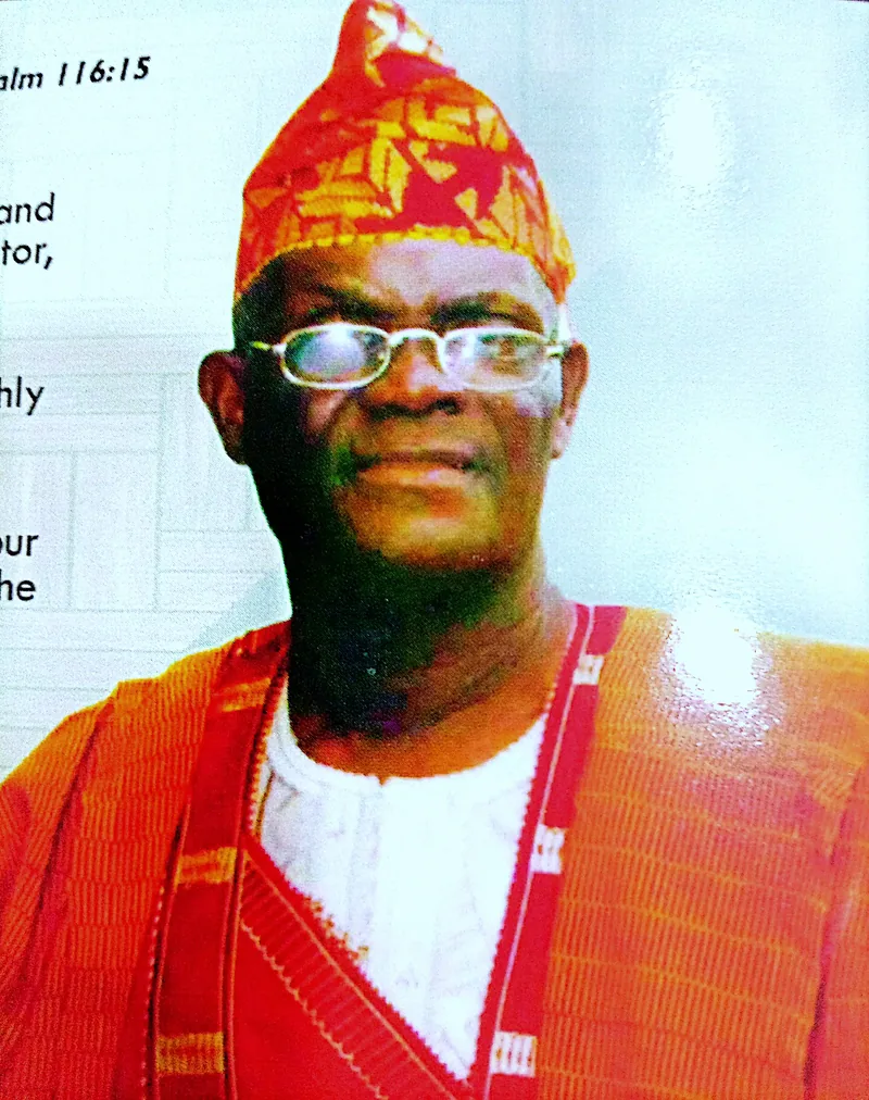 Papa Elkanah Osibanjo in later life, wearing red aso-oke and a patterned cap.