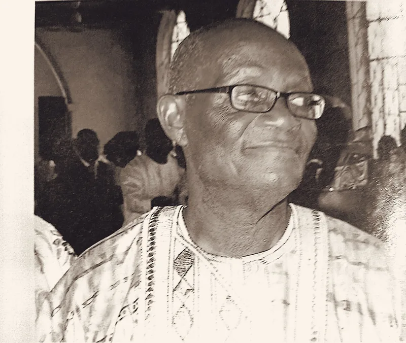 Papa Elkanah Osibanjo smiling at a gathering, in adire agbada.