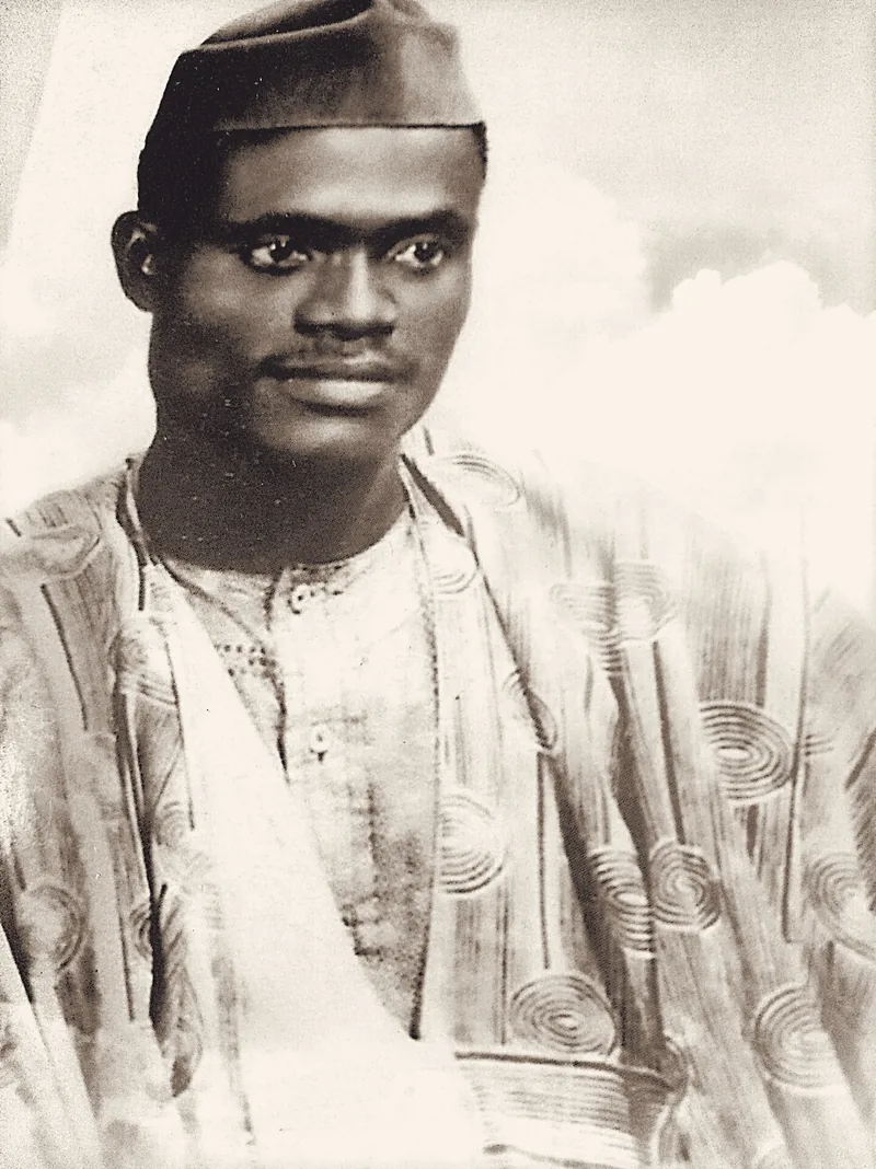 Papa Elkanah Osibanjo as a young man, in embroidered agbada and cap, photographed in the 1950s.